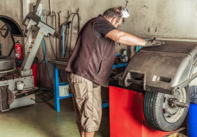 mechanic-using-electric-tools-repair-wheel balance wheel garage fule equipment