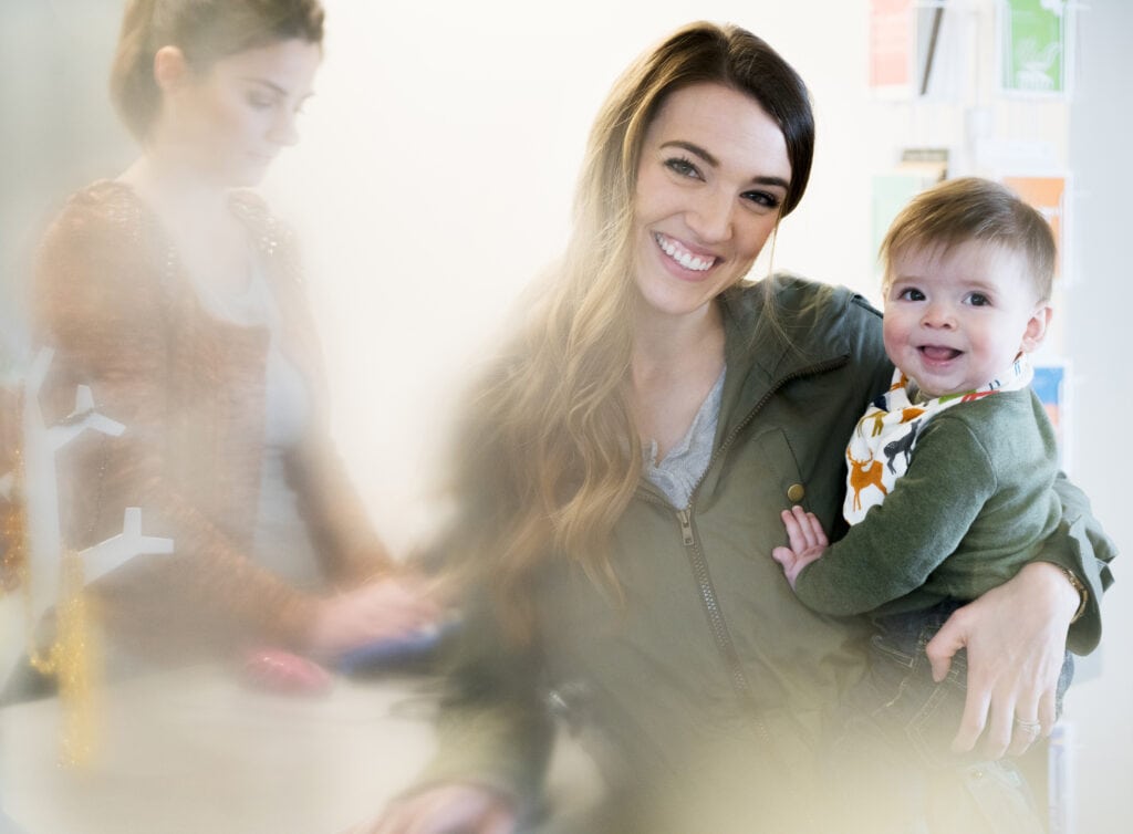 Edmonds,usa,woman holding a baby standing next to a cash register with shop assistant, smiling at camera.