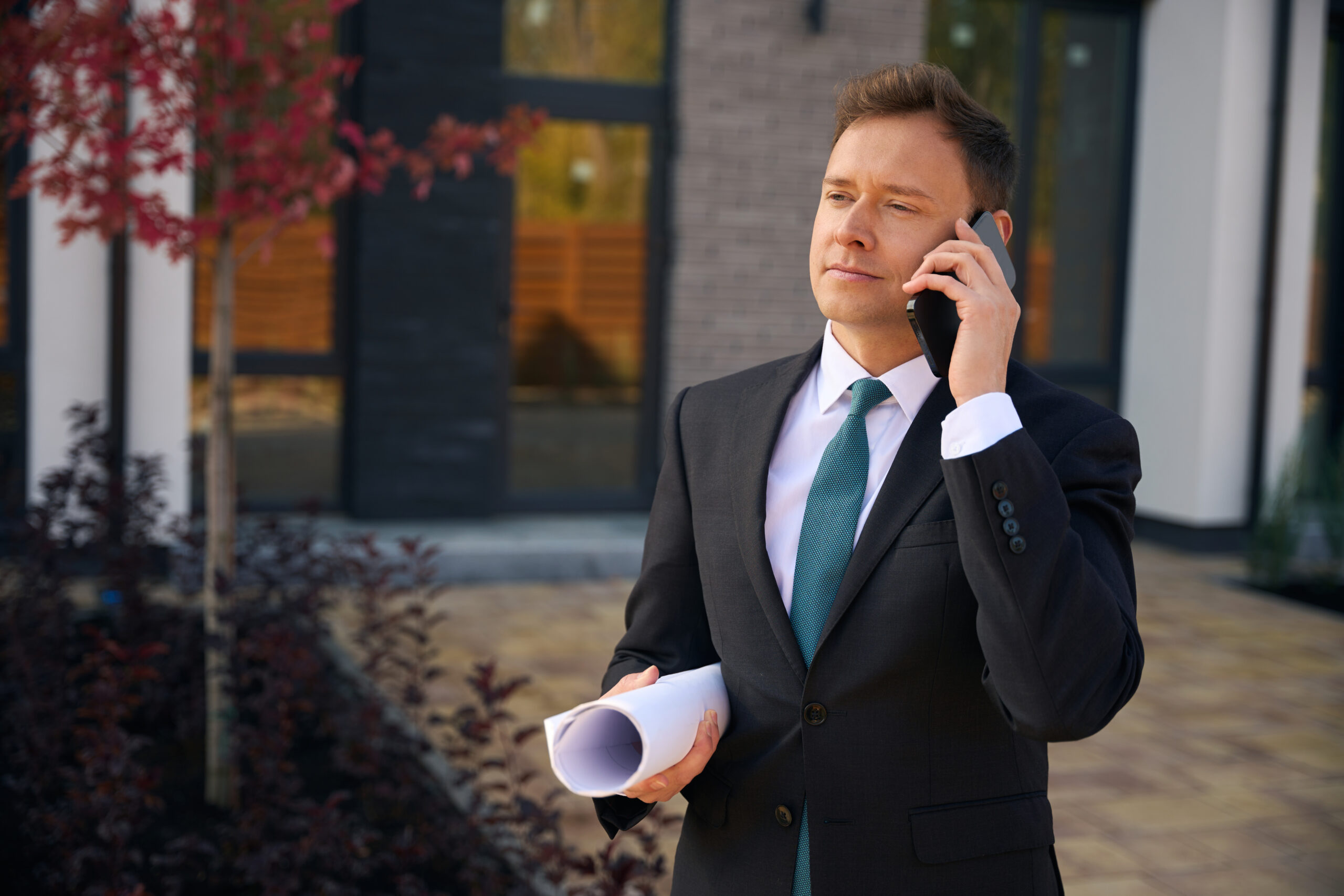 Calm man standing and talking on mobile phone