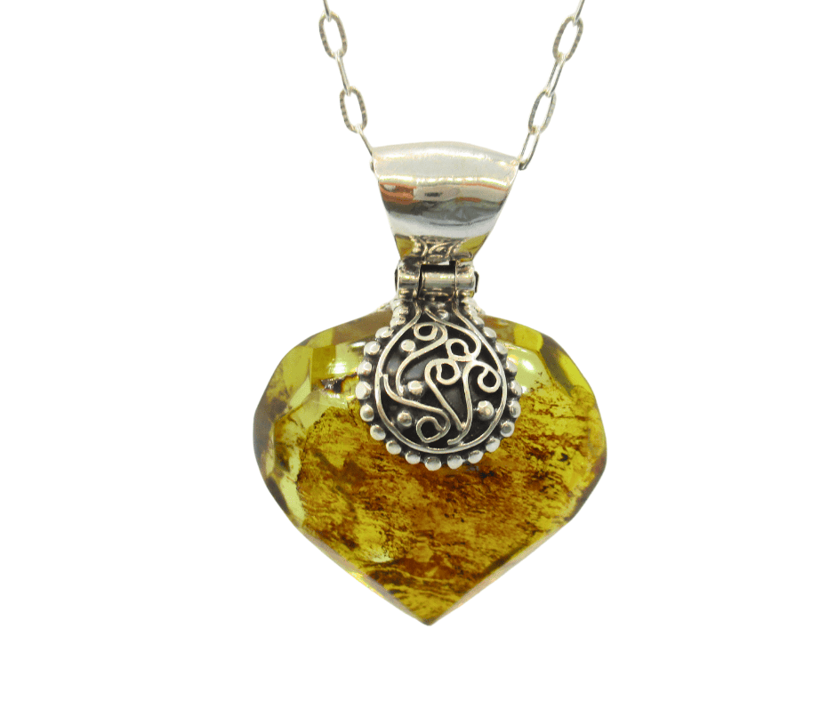 Cruz de piedra tallada con colgante de plata en forma de corazón, joyería artesanal mexicana, símbolo de amor y tradición, hermoso diseño de HETS'I LUVI.