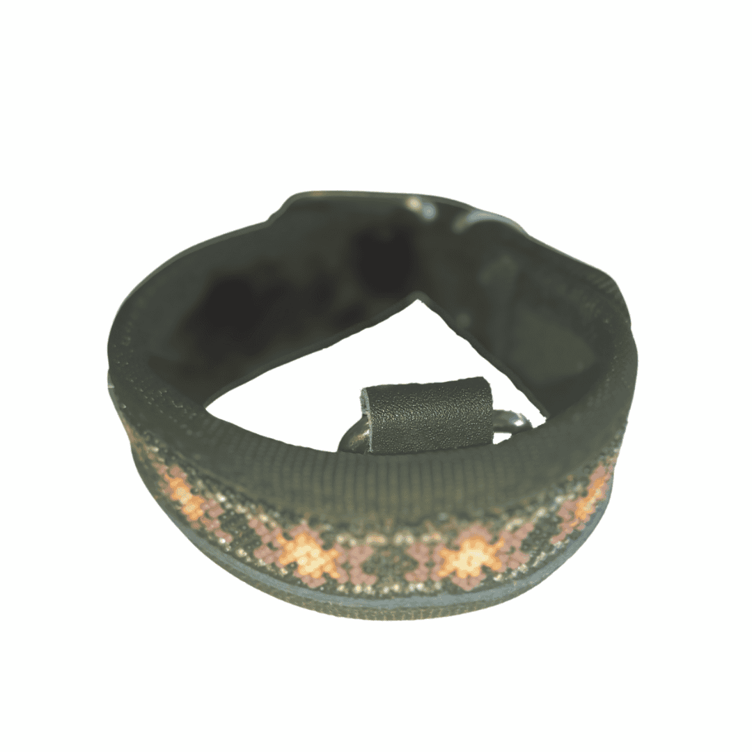 Pulsera de tela tejida a mano con diseño colorido en tonos rosas y beige, ideal para accesorio bohemio y artesanal.