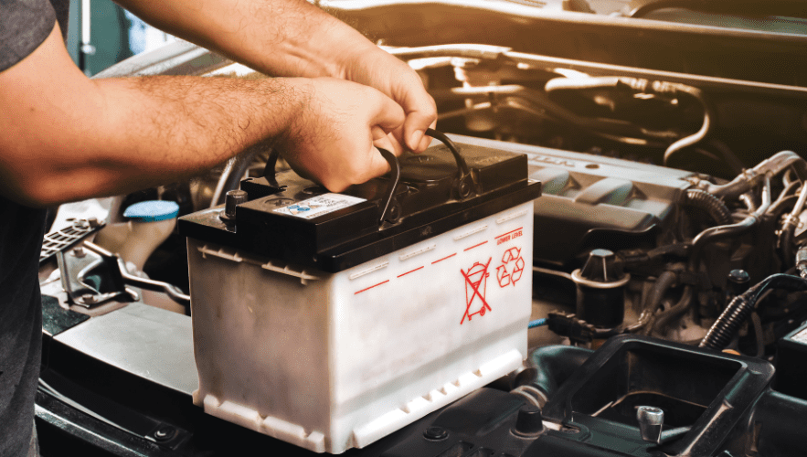 Car battery being replaced at Hillside Auto Clinic for optimal vehicle performance.