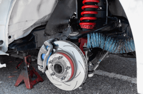 Close-up of car brake system with suspension components.