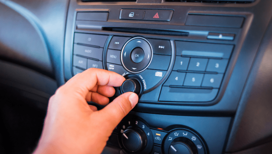 Close-up of a person adjusting a car's climate control panel.
