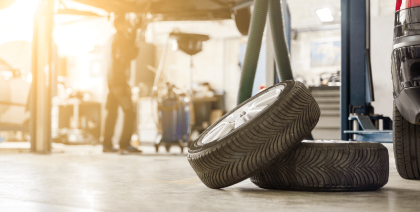 Car tire being replaced at auto repair shop in a modern garage setting.
