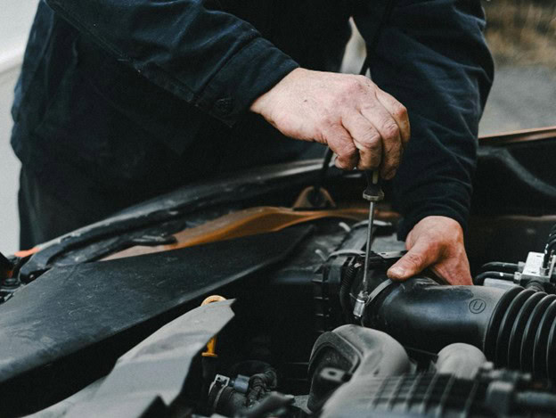 Technician performing engine diagnostics to prevent major repairs and ensure vehicle reliability.