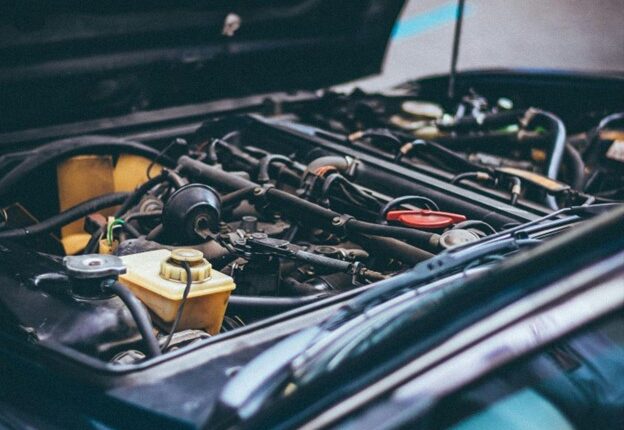 Engine diagnostic tools inspecting vehicle engine components.