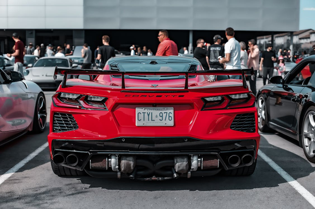 Red Chevrolet Corvette sports car at a car show, emphasizing vehicle performance and style.