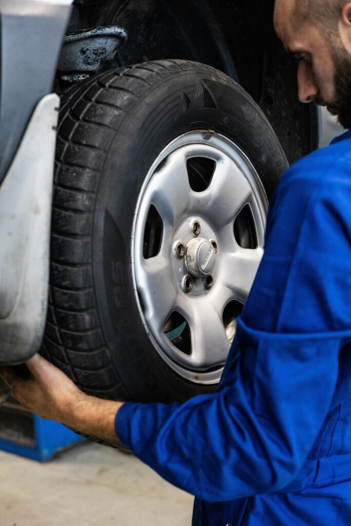 Auto mechanic inspecting a car tire for safety and performance at Hillside Auto Clinic.