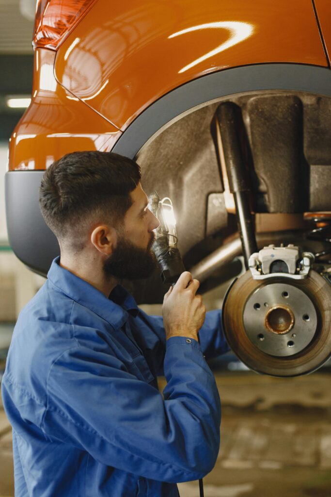 Auto mechanic inspecting a vehicle's brake system at Hillside Auto Clinic.