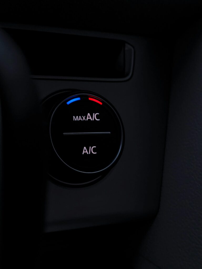 Car climate control panel with A/C and max A/C settings in vehicle interior.