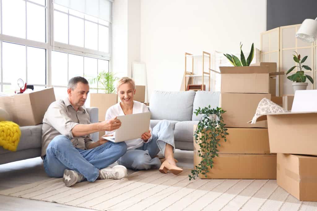 Mature Couple Using Laptop In Room On Moving Day