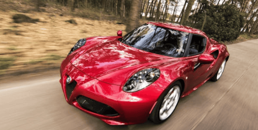 Alfa Romeo sports car driving on a scenic road, emphasizing performance and style.