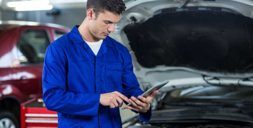 Technician inspecting car engine for trip readiness at Honest Engine Roseville.