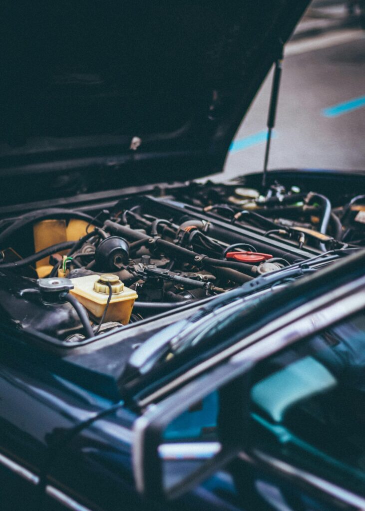 Engine bay of a modern vehicle with open hood showing engine components.
