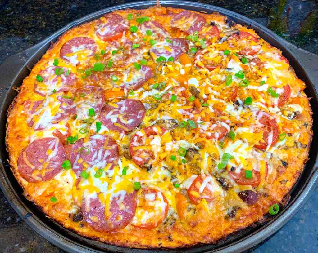 Cheesy pepperoni and vegetable pizza fresh from the oven with green onions topping.