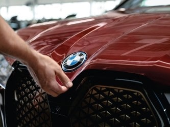 Close-up of a person polishing a red BMW at Imola Motorsports.