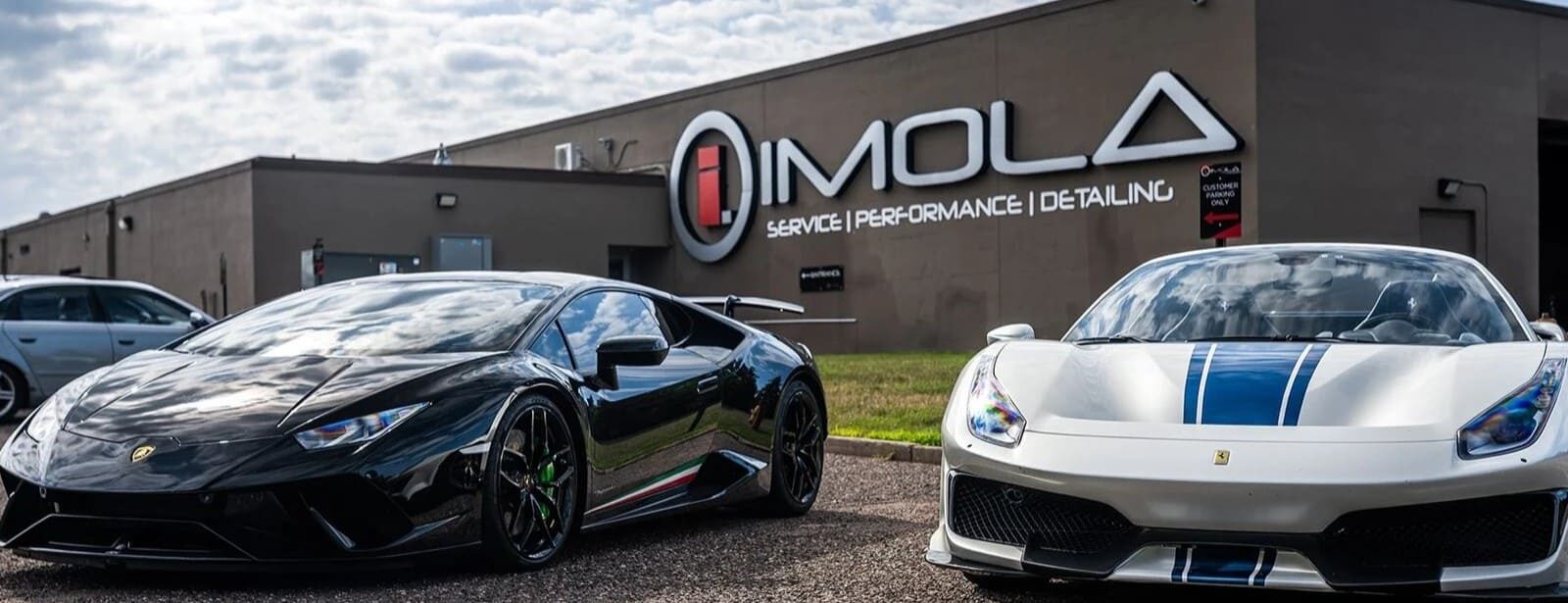 Luxury sports cars at Imola Motorsports dealership in California.
