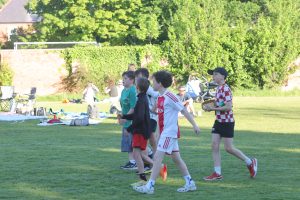 Children playing soccer outdoors in Inchmarlo community park, scenic green landscape in Scotland.
