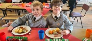 Two boys enjoying lunch at Inchmarlo, a scenic village with family-friendly amenities and beautiful surroundings.