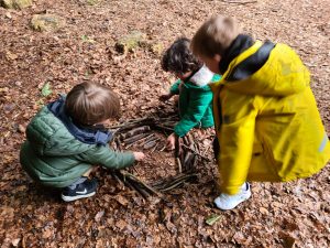 Children exploring woodland outdoors in nature at Inchmarlo.