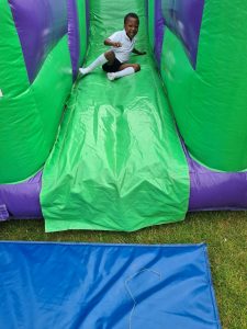 Child enjoying inflatable slide at Inchmarlo outdoor event.