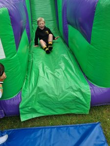 Child enjoying a colorful inflatable slide at Inchmarlo outdoor activity center.