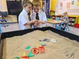 Two children engaged in educational activity in a classroom setting.