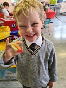 Happy boy holding toy in classroom.