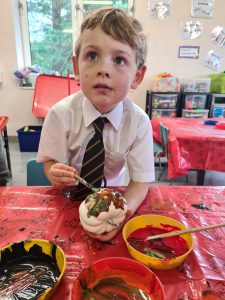 Young boy enjoying art activity at Inchmarlo School in Scotland, engaging in creative learning.