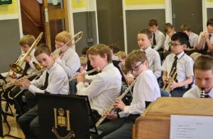 School band practicing with instruments in a classroom.