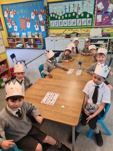Children in a classroom wearing paper crowns.