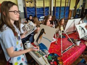 Young students painting penguins at art workshop, educational activity at Inchmarlo School in Aberdeen.