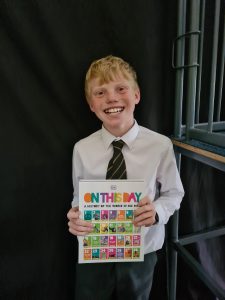 Happy schoolboy holding birthday poster at Inchmarlo School, Aberdeen.