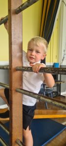 Young boy playing at Inchmarlo residential care home, enjoying outdoor climbing activities.