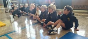 Children seated on the floor participating in educational activities at Inchmarlo.