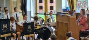 Young students performing guitar during school music class at Inchmarlo.