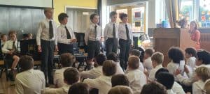 School children performing choir at Inchmarlo with attentive audience.