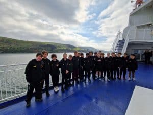 Group of students on Inchmarlo boat trip in Scotland, scenic river views in background.