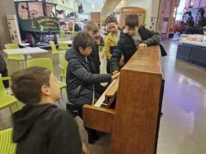 Children enjoying playing piano at Inchmarlo. Educational activities for children in a friendly environment.