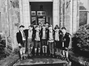Group of children standing outside Inchmarlo estate in Scotland, smiling and posing for a photo.