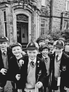 Young children in school uniforms outside Inchmarlo estate, showcasing historical and educational significance.