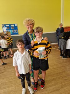 Happy children with teacher in school hall, engaging in activity.