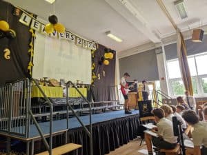 Students performing on stage at Inchmarlo primary school event in a well-lit hall.