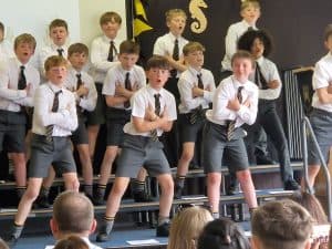 Students performing energetic dance on stage at Inchmarlo School event.