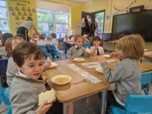 Kids eating lunch at Inchmarlo School in a vibrant classroom setting.