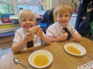 Two children enjoying soup at Inchmarlo, showcasing a warm, friendly atmosphere for kids and families.