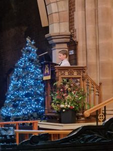 Festive scene at Inchmarlo with a decorated Christmas tree and child enjoying holiday decorations.