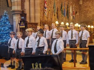 Children singing at Inchmarlo residential care home event, highlighting community and senior care services.