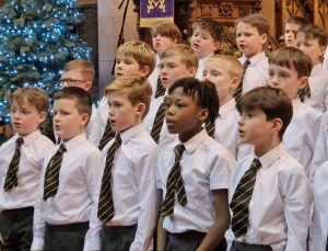 Young students singing at Inchmarlo school event, celebrating community and music education.